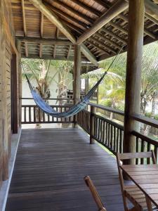 a hammock on the porch of a house at App Lory KiteVillage in Uruau +11 photos