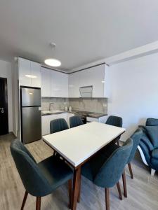 a kitchen and dining room with a table and chairs at Mehmeti Apartment in Sarandë