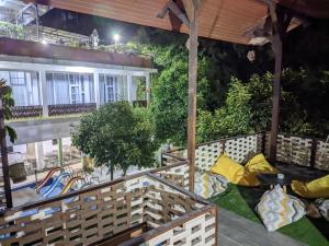 an outdoor patio at night with yellow pillows at Sarasutha hotel and pool in Lembuak