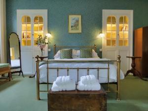 a bedroom with a bed with shoes on a trunk at The Hall Estate - Historic Grade I-listed Jacobean Mansion in Bradford on Avon