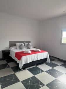a bedroom with a bed with a red and white blanket at B6 Hotel in San Fulgencio