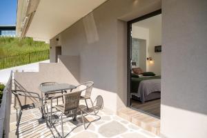 a balcony with a table and chairs and a bedroom at Sithonia Blue in Neos Marmaras
