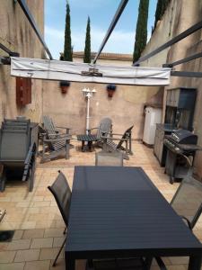 a patio with a table and chairs and a grill at Chambres chez l'habitant in Valréas