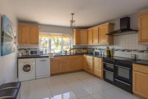 a kitchen with wooden cabinets and a washer and dryer at Loch View House in Loch Gowna in Lough Gowna