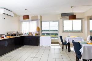 a kitchen with two tables and chairs and a kitchen with windows at Résidences Les Hauts de l'Indenié in Abidjan