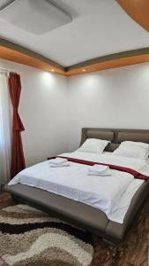 阿尔杰什河畔库尔泰亚Vila Simona的一间卧室，里面有一张铺着白色床单的大床。