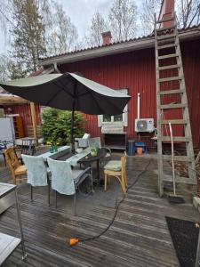 a patio with an umbrella and a table and chairs at Private room in a 250 years old house in Helsinki