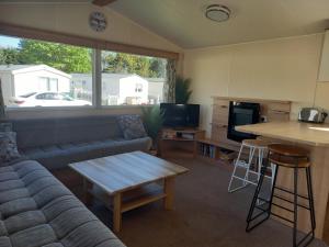 una sala de estar con un sofá y una mesa en Seton Sands Haven Park Moonstone Caravan, en Port Seton