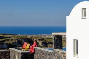 a balcony with chairs and a view of the ocean at Avan Luxury Villas in Pyrgos