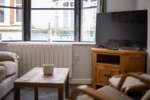 ブリクサムにあるNelson's Quarters- Harbour & High Streetのテレビとコーヒーテーブルのあるリビングルーム