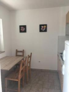 a kitchen with a wooden table and chairs in a room at Apartment IB Studio Pag6 in Kustići +9 photos