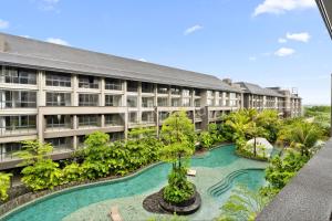 un edificio de apartamentos con piscina frente a él en Rivana by Kozystay - Nusa Dua, en Nusa Dua
