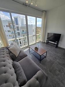 a living room with a large couch and a piano at Studio by The Sea in Limassol