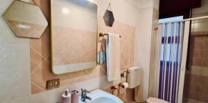a bathroom with a sink and a mirror and a toilet at Casa Costa in Lipari +30 photos