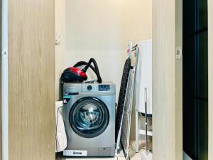 eine Waschmaschine in einer Ecke eines Zimmers in der Unterkunft Luxurious 1 BR in District One Beach Access in Dubai