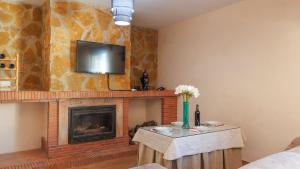 a living room with a fireplace and a tv on a wall at Villa Ortega Alba Alcalá La Real by Ruralidays in Alcalá la Real