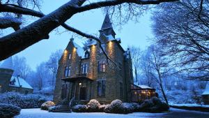 an old house in the snow at night at Châteaux de Méliris in Tenneville