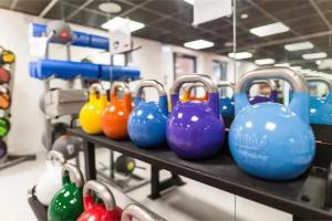 a row of colorful dumbbells on a shelf at Paradise Village Coventry in Coventry