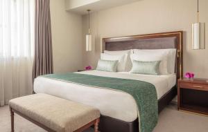 a bedroom with a large bed with a green blanket at Tivoli Avenida Liberdade Lisboa – A Leading Hotel of the World in Lisbon