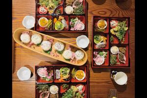 a wooden table with several plates of food on it at Farm To Table NORICHIE 1日1組限定の一棟貸し 田園風景と星空を楽しむ 自家農園&地元食材の夕朝食付き in Senboku