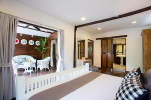 a bedroom with a white bed and a table and chairs at Tolani Northgate Villa Chiang Mai in Chiang Mai +69 photos