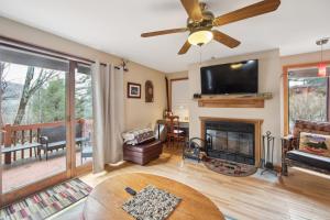 a living room with a fireplace and a ceiling fan at Sagamore 46G - Adirondack Retreat for All Seasons in North Creek