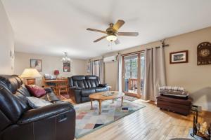 a living room with leather furniture and a ceiling fan at Sagamore 46G - Adirondack Retreat for All Seasons in North Creek