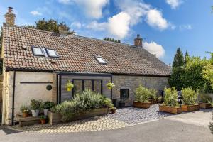 a house with potted plants in front of it at Apothecary Cottage - Pet Friendly Wedmore Couples Cottage - Free WiFi - Free Parking in Wedmore