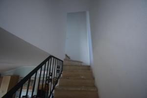a staircase in a house with a white wall at Villino Le Palme, Laghi Di Sibari, Cosenza in I Casoni +6 photos