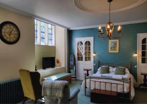 a bedroom with a bed and a clock on the wall at The Hall - Historic Grade I-listed Jacobean Mansion in Bradford on Avon