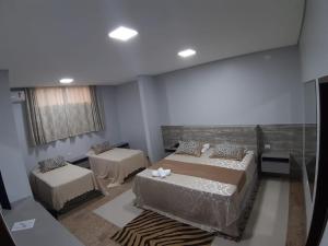 a room with two beds and a room with two tables at Hotel O Recanto in Campo Mourão +24 photos