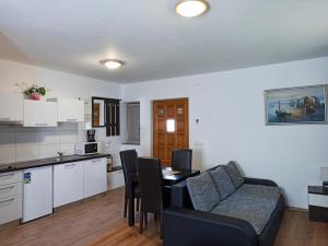 a kitchen and a living room with a couch and a table at Plitvice Lakes Holiday Lodge in Rudanovac