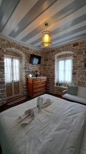 een slaapkamer met een groot wit bed in een kamer bij 1836 Traditional House in Vathi