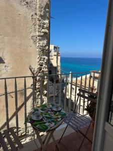 a table on a balcony with a view of the ocean at Affaccio sul Mare in Tropea