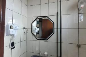 a mirror on the wall of a bathroom with a phone at AP102 - Apartamento com AC no centro in São Miguel dʼOeste
