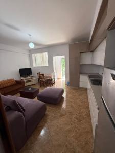 a living room with a couch and a kitchen at Heart of Vlore Walk to Beach in Vlorë