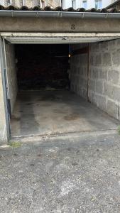 eine leere Garage mit einer Ziegelwand und einem Betonboden in der Unterkunft Coup de cœur parisien à 15 mn de Paris - 45 mn Disney in Noisy-le-Sec