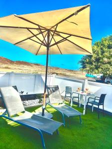 a patio with a table and chairs and an umbrella at Casa Gary in Caleta de Caballo