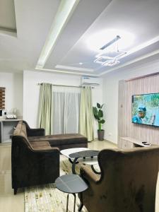 Una sala de estar con dos sofás y una mesa. en Gemmes Apartment, en Lekki