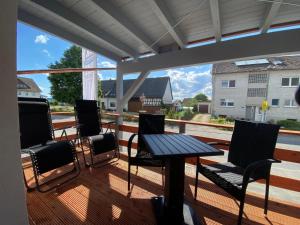a patio with a table and chairs on a deck at Ferien & Business Apartments Hohenfels in Hohenfels