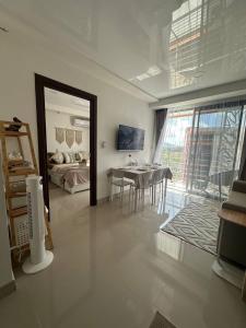 Una sala de estar con una mesa y un dormitorio. en Boho Apartment, en Mai Khao Beach