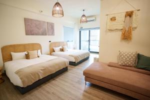 a bedroom with two beds and a couch at 墾丁包棟民宿-宇樂 in Hengchun +25 photos