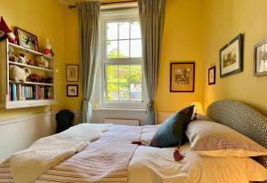 ein Bett in einem Zimmer mit Fenster in der Unterkunft The West Wing - Bride Valley - Jurassic Coast in Long Bredy