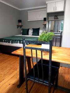 a bedroom with a bed and a wooden table at Tevrede Guest Cottage in Bloemfontein