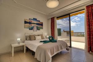 ein Schlafzimmer mit großem Bett und Balkon in der Unterkunft Penthouse 501 Gara Jonay terrace sea view in Costa de Adeje + 50 Fotos