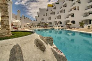 ein Schwimmbad vor einem großen Gebäude in der Unterkunft Penthouse 501 Gara Jonay terrace sea view in Costa de Adeje