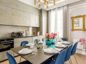 Merveil - Signature Suite - Louvre - Victoria في باريس: غرفة طعام مع طاولة وكراسي زرقاء