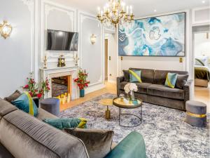 Merveil - Signature Suite - Louvre - Victoria في باريس: غرفة معيشة مع كنب ومدفأة