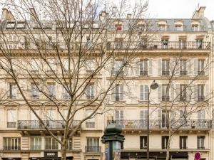 Merveil - Signature Suite - Louvre - Victoria في باريس: شجرة أمام مبنى كبير