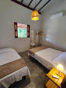 a room with two beds and a window at Casa Cajá - praia, natureza & conforto em Boipeba in Ilha de Boipeba